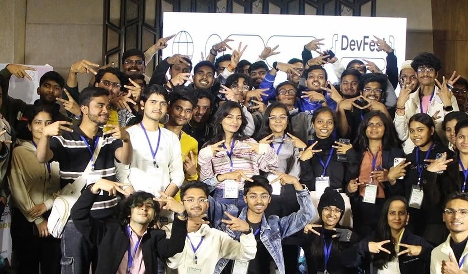 Attendees crowded together for a group photograph in front of the DevFest backdrop at DevFest Indore.